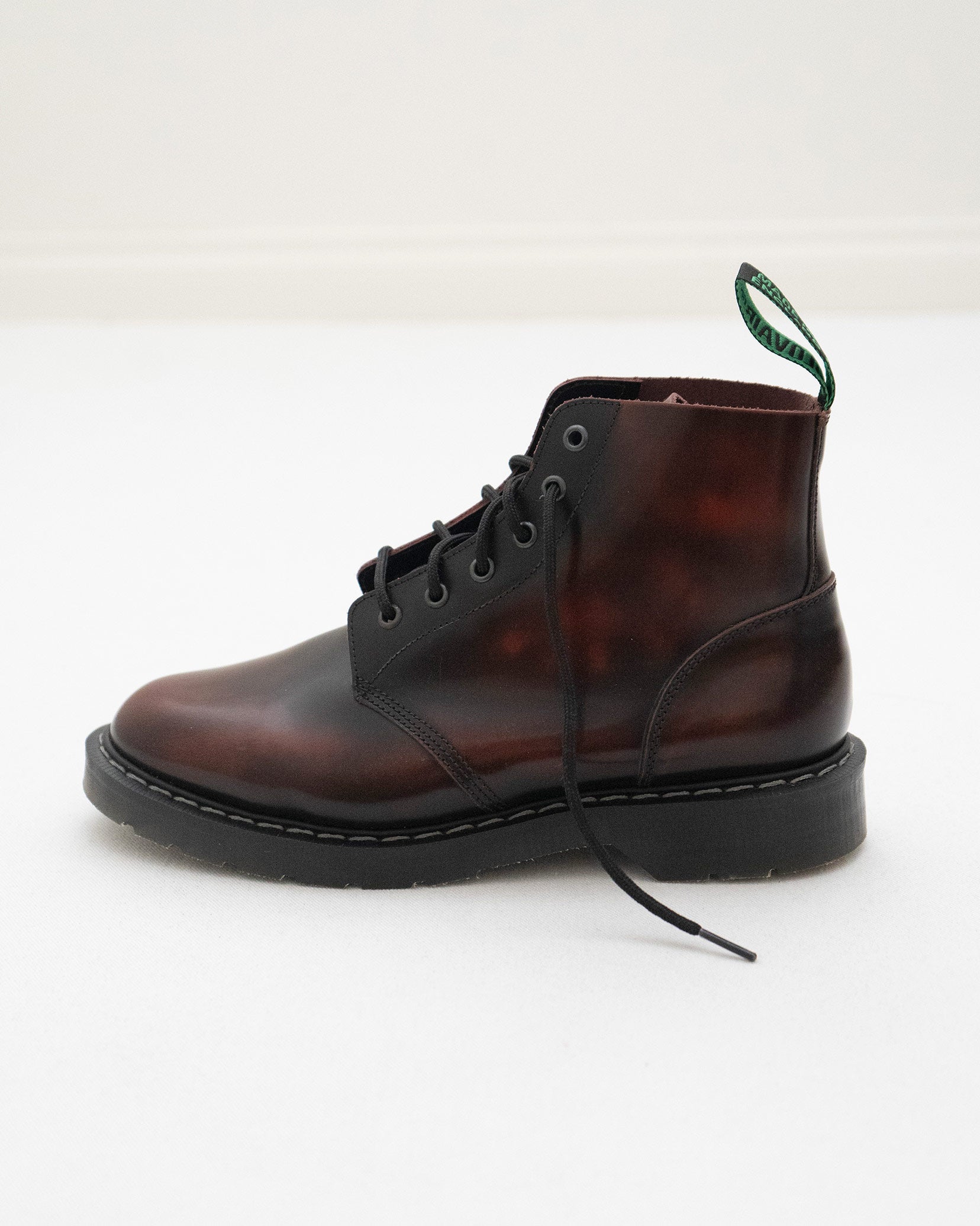 The Solovair Burgundy Leather Astronaut Boot by Pyne and Smith Clothiers features a thick Goodyear welted sole, lace-up design, and green pull tab, displayed on a white surface with a minimal background.