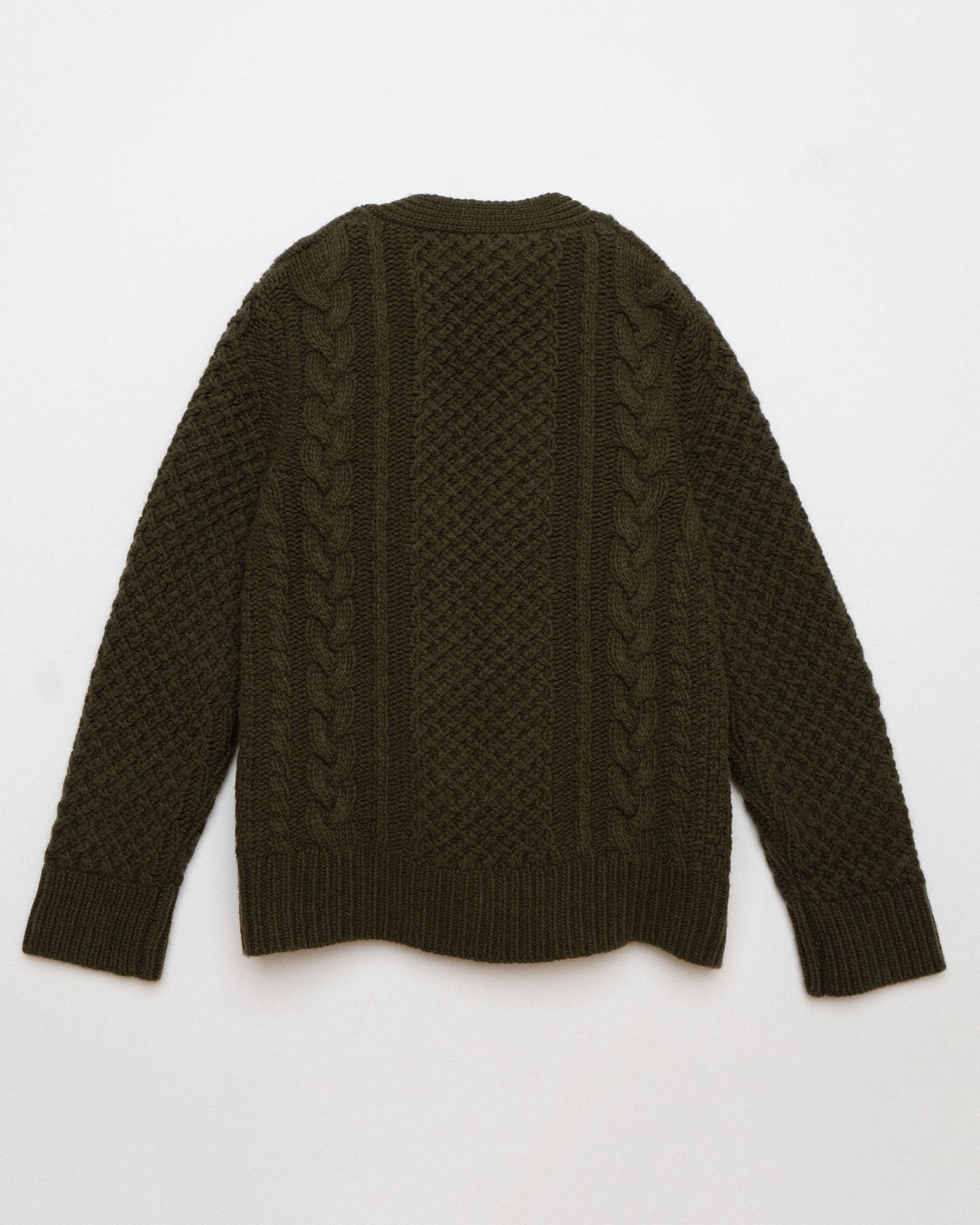 The Merino Wool Cable Knit Cardigan with Pockets in Brunswick Green by Pyne and Smith Clothiers is laid flat, back facing up, showcasing its long sleeves, chunky cable knit, and all-over textured pattern.