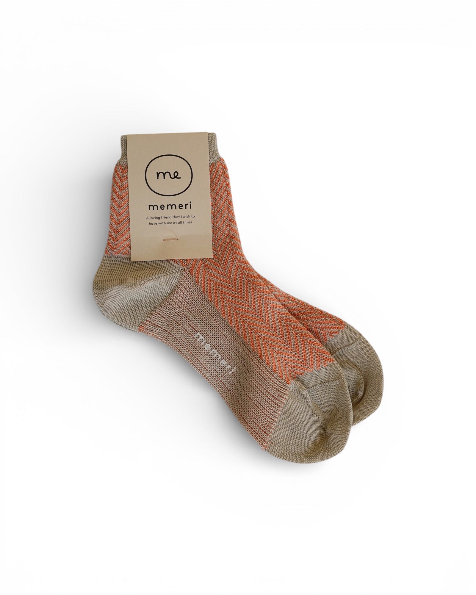 A pair of Coral Pink Giza Cotton Socks from Pyne and Smith Clothiers, featuring a zigzag pattern in coral pink and beige, displayed against a white background with a cardboard tag attached.