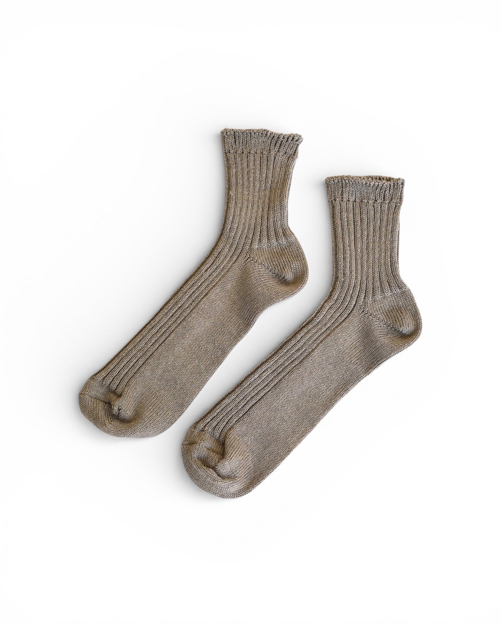 A pair of Linen Ribbed Socks in Beige by Pyne and Smith Clothiers are laid flat on a white background with toes pointing slightly left, offering comfort and style.