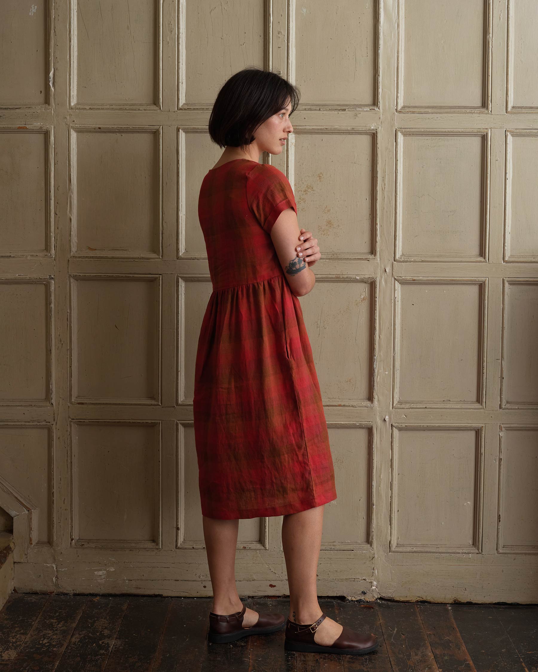 Model showing back view of linen midi day dress in red Paloma Check with pockets