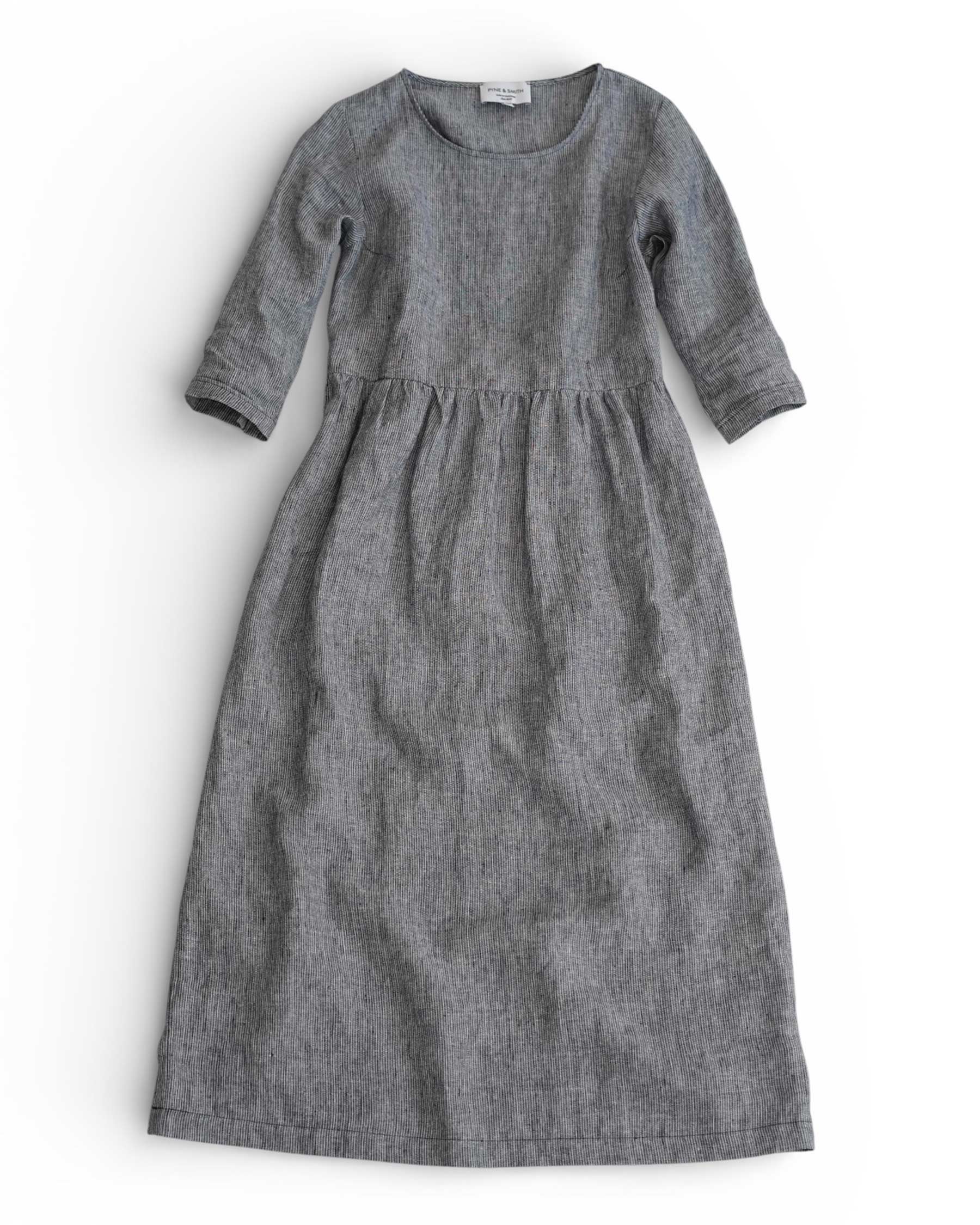The No.41 Full Length Linen Day Dress in Cooke’s Stripe by Pyne and Smith Clothiers features long sleeves, an ankle-length striped gray linen design, a fitted bodice, and an adjustable waist tie, displayed flat on a white background.