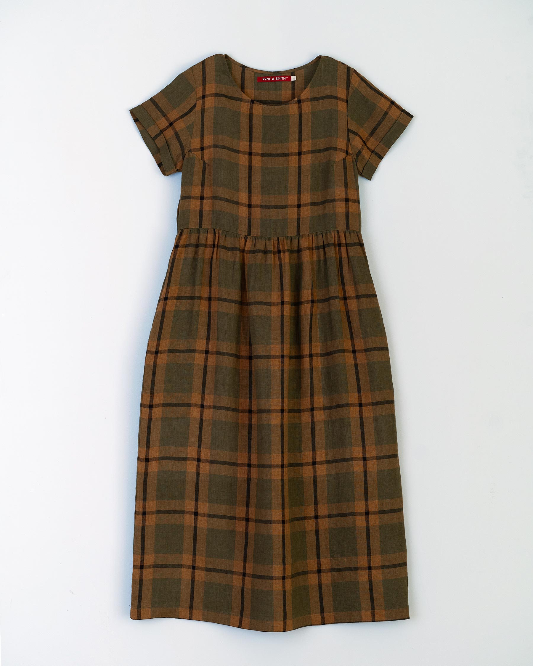 Flat lay of full length linen tea dress with pockets in green, tan and black The George Plaid