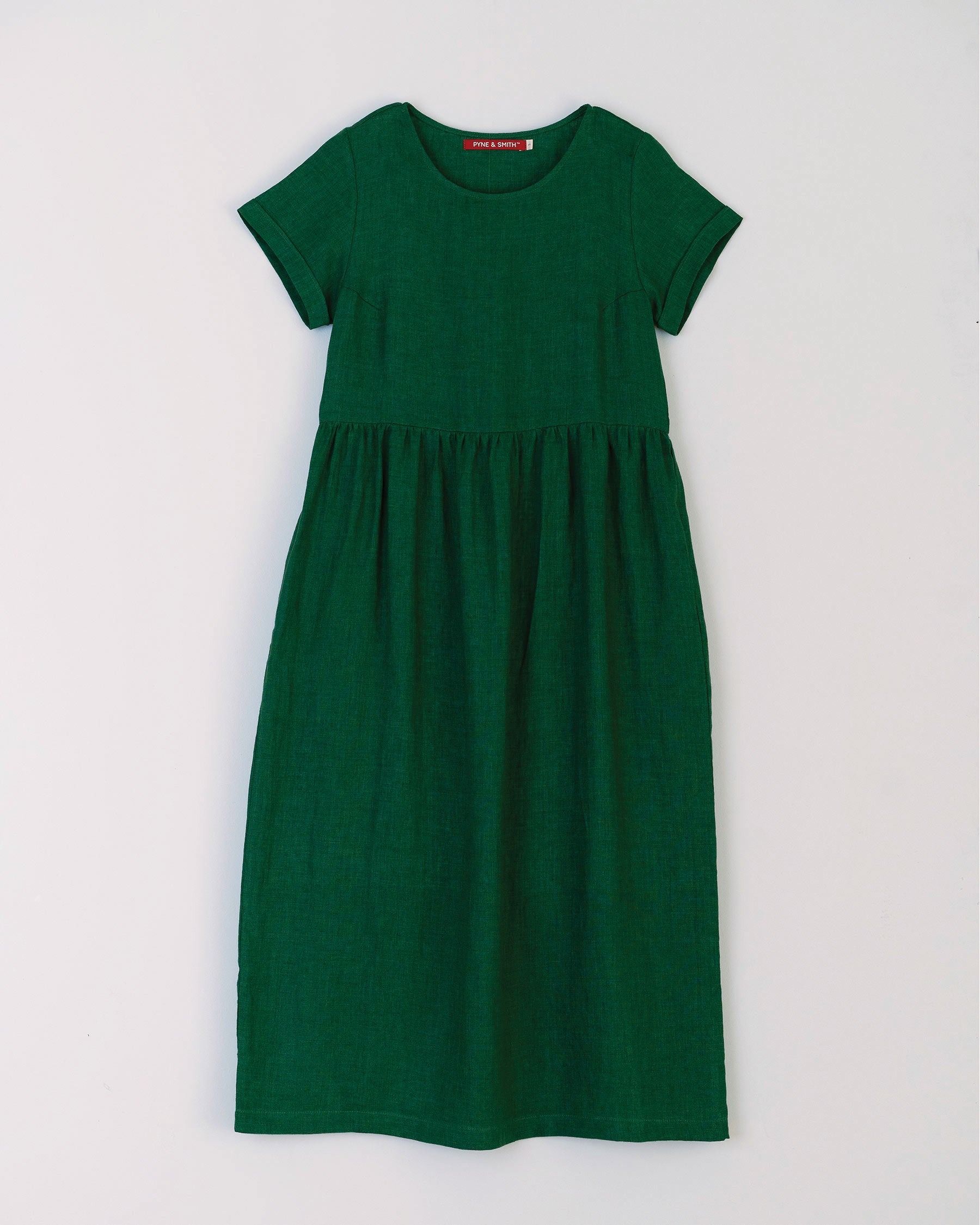 Flat lay of full length linen tea dress in viridian green with pockets