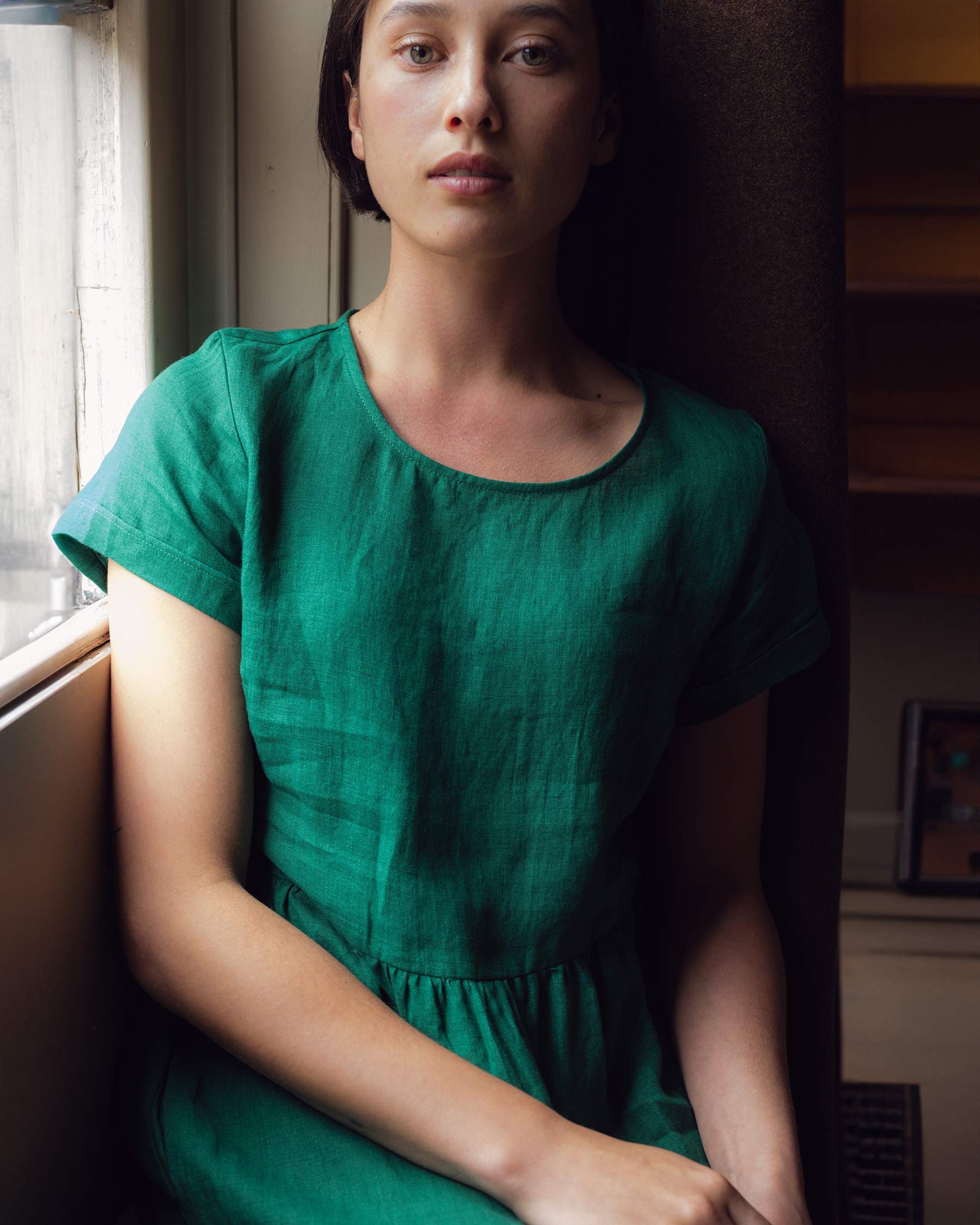 Close up of model wearing no. 17 linen tea dress showing short sleeves with folded cuff and bodice