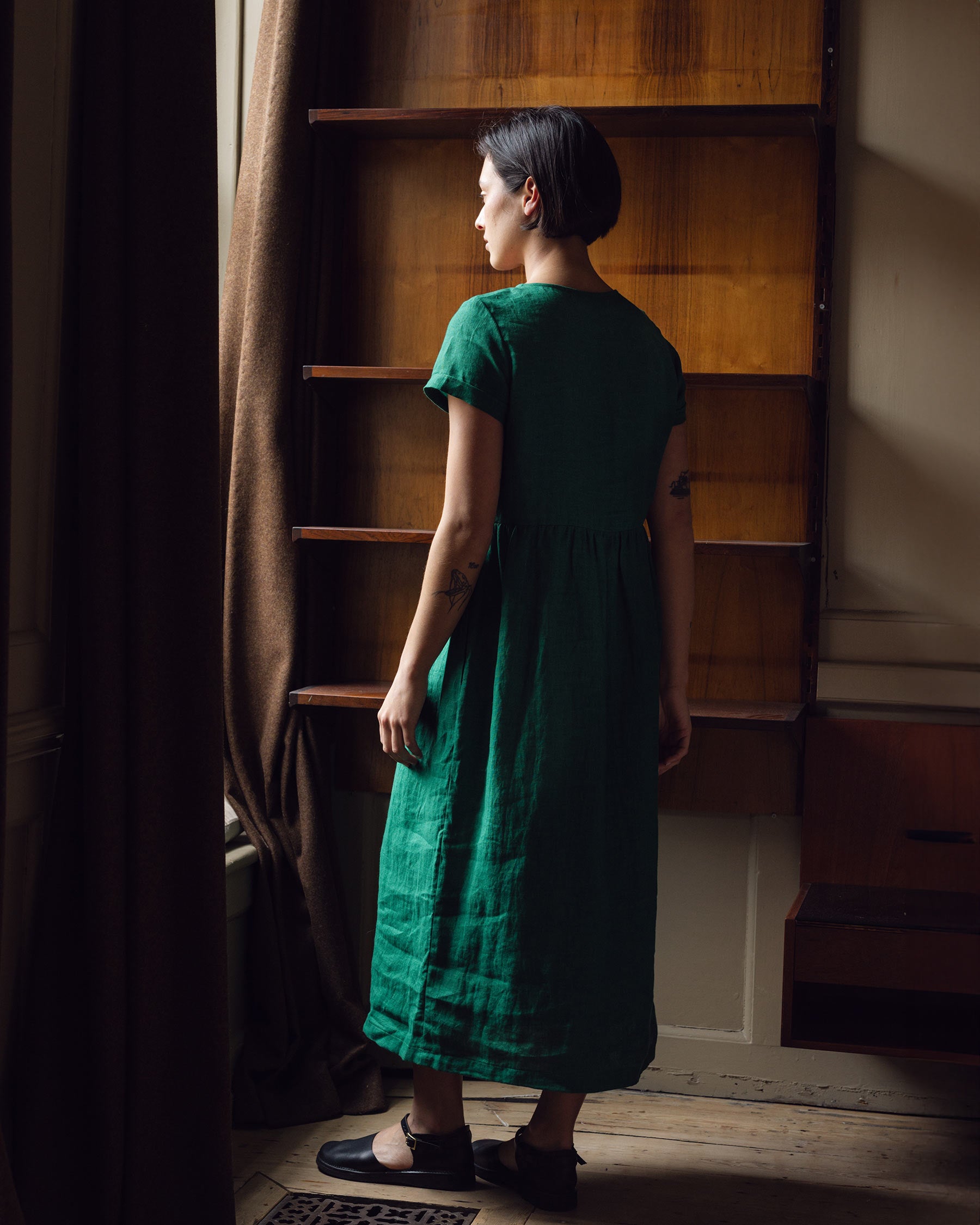 Back view of model wearing full length linen tea dress in viridian green