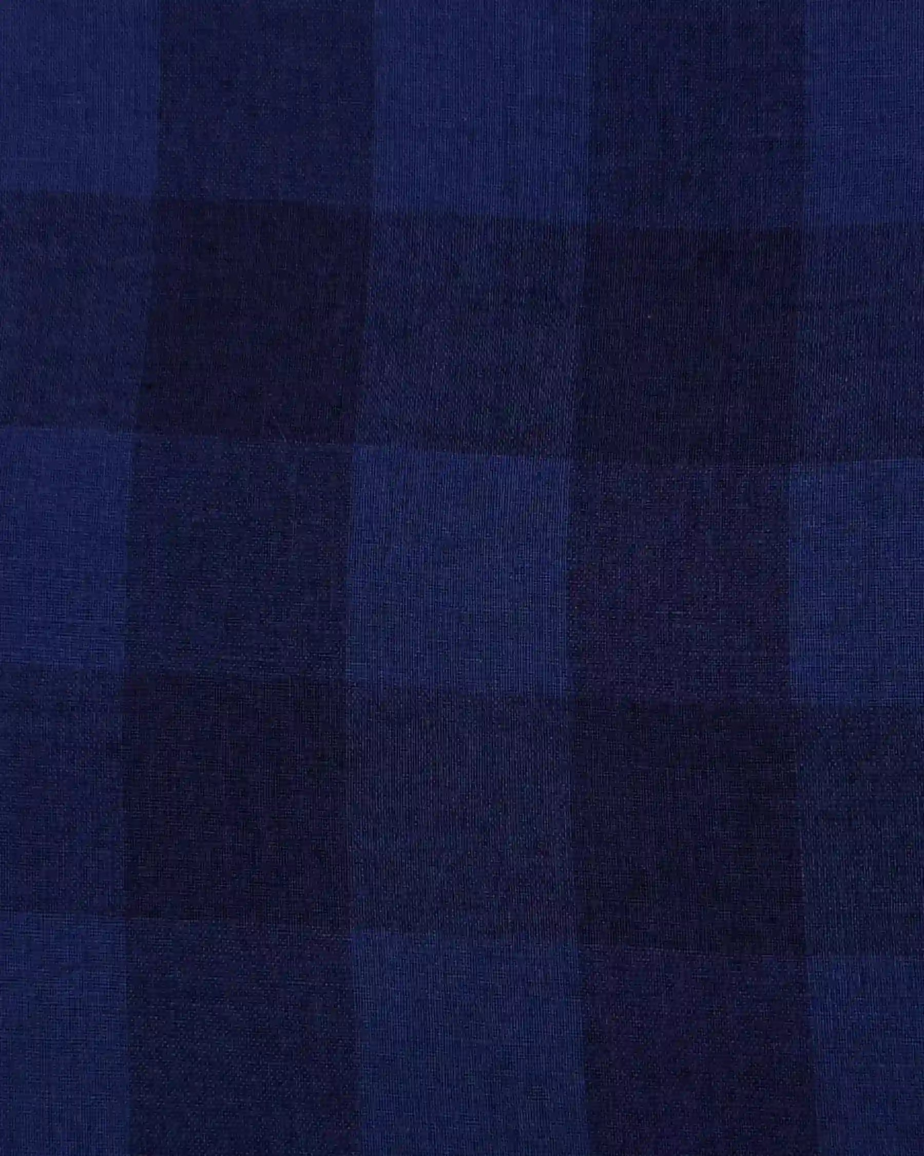 A close-up of Pyne and Smith Clothiers' Linen Skirt No.14 in Midsommar Night Check, showcasing its dark blue and navy plaid pattern with large squares and varied blue stripes.