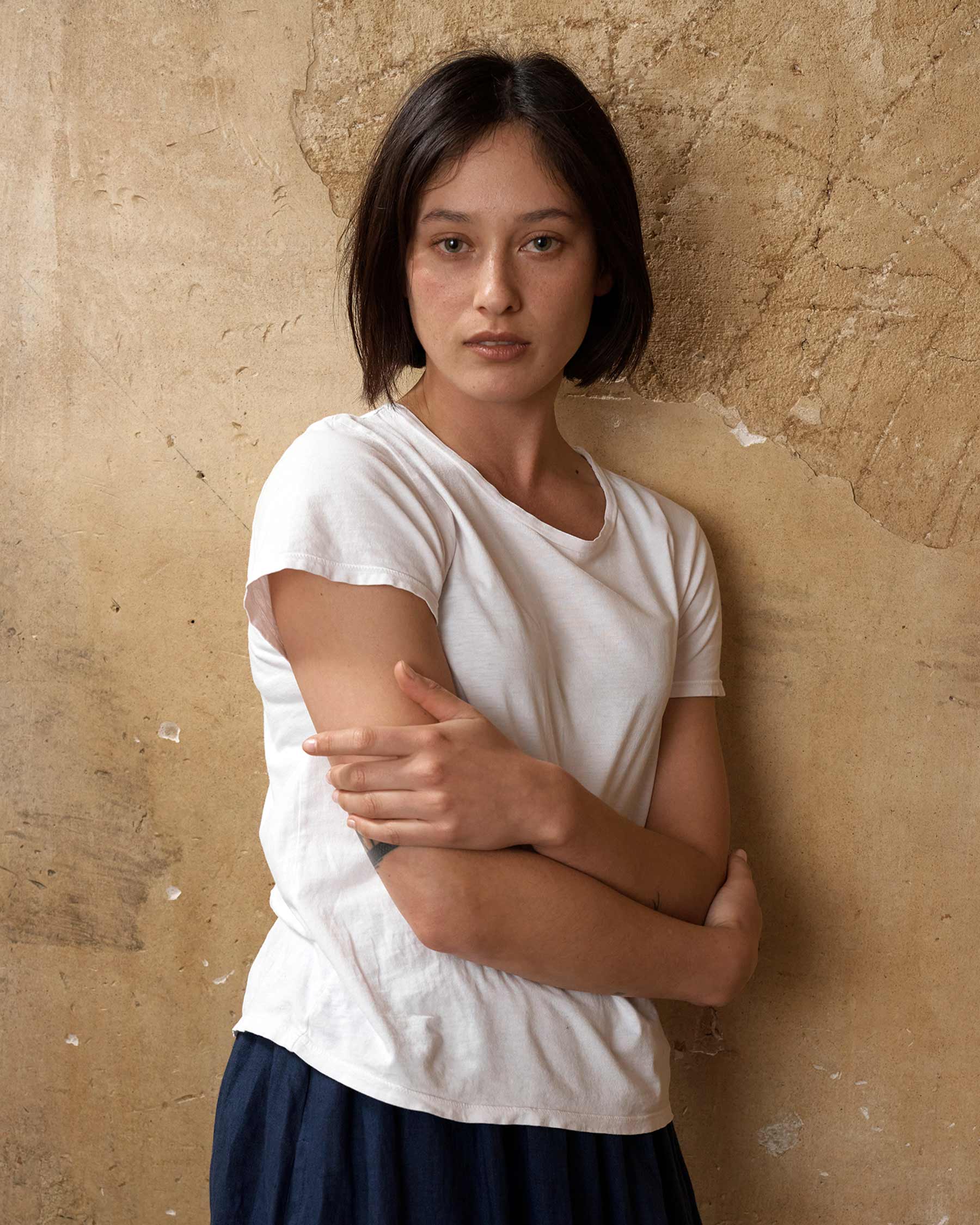 Side view of organic cotton t-shirt in white with Navy Blue linen skirt with pockets