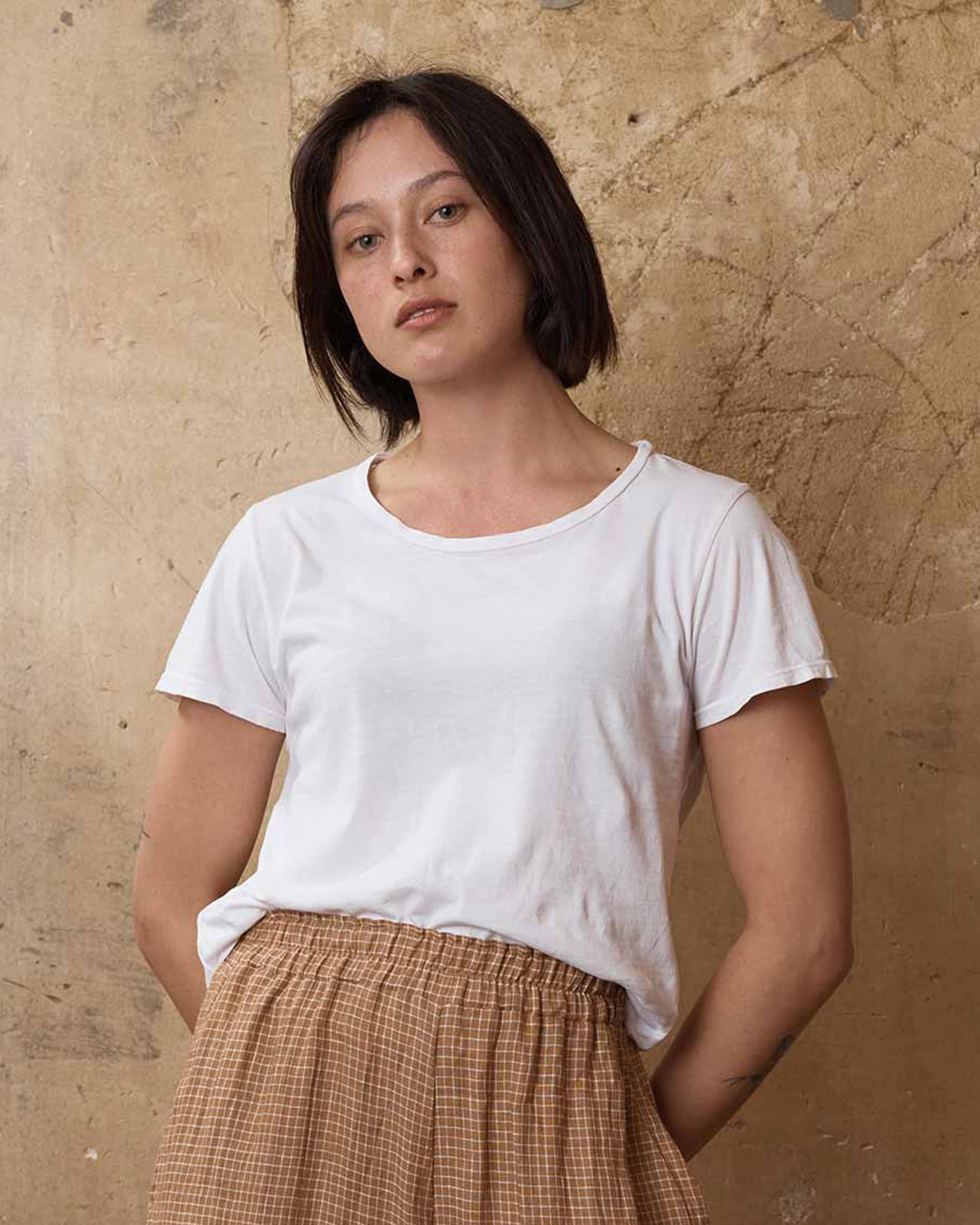 Front view of organic cotton t-shirt in white tucked into linen culottes