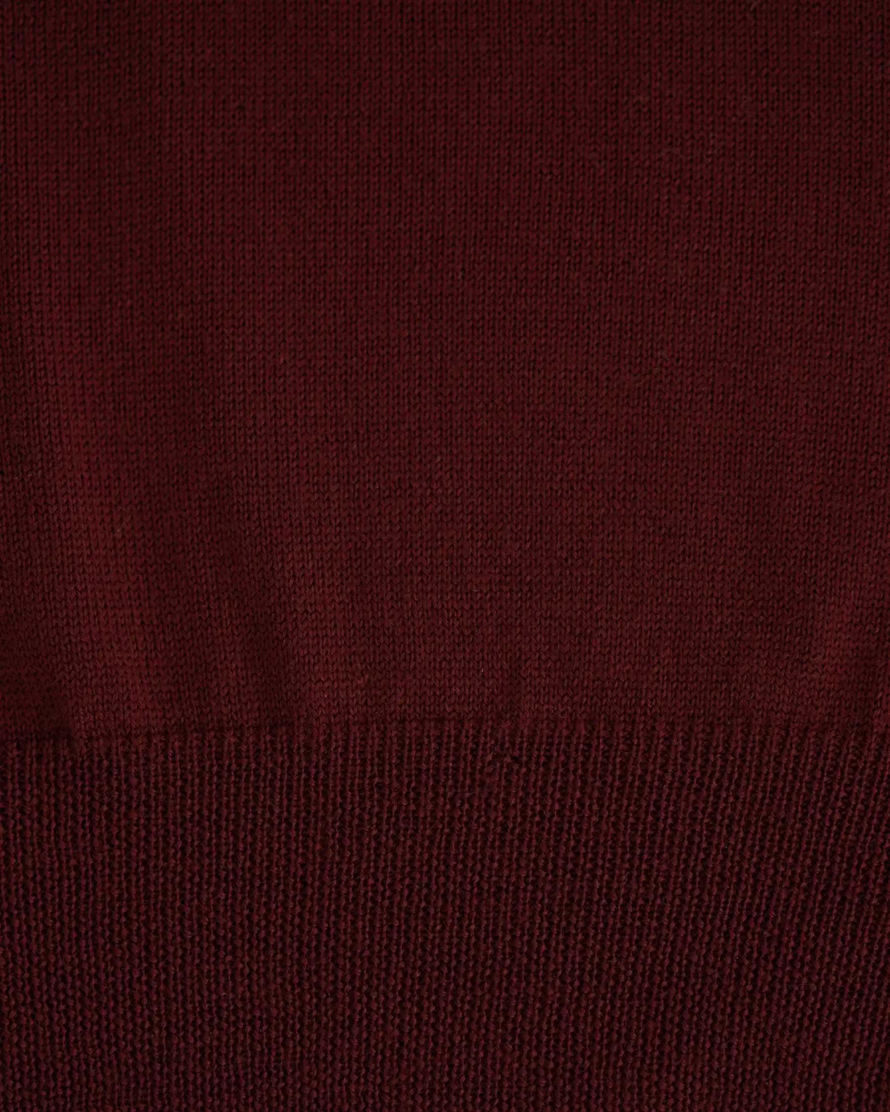 A close-up of the Merino Polo Shirt in Rosso by Pyne and Smith Clothiers, showing its burgundy extra fine merino wool knit with a visible ribbed edge and detailed yarn texture.
