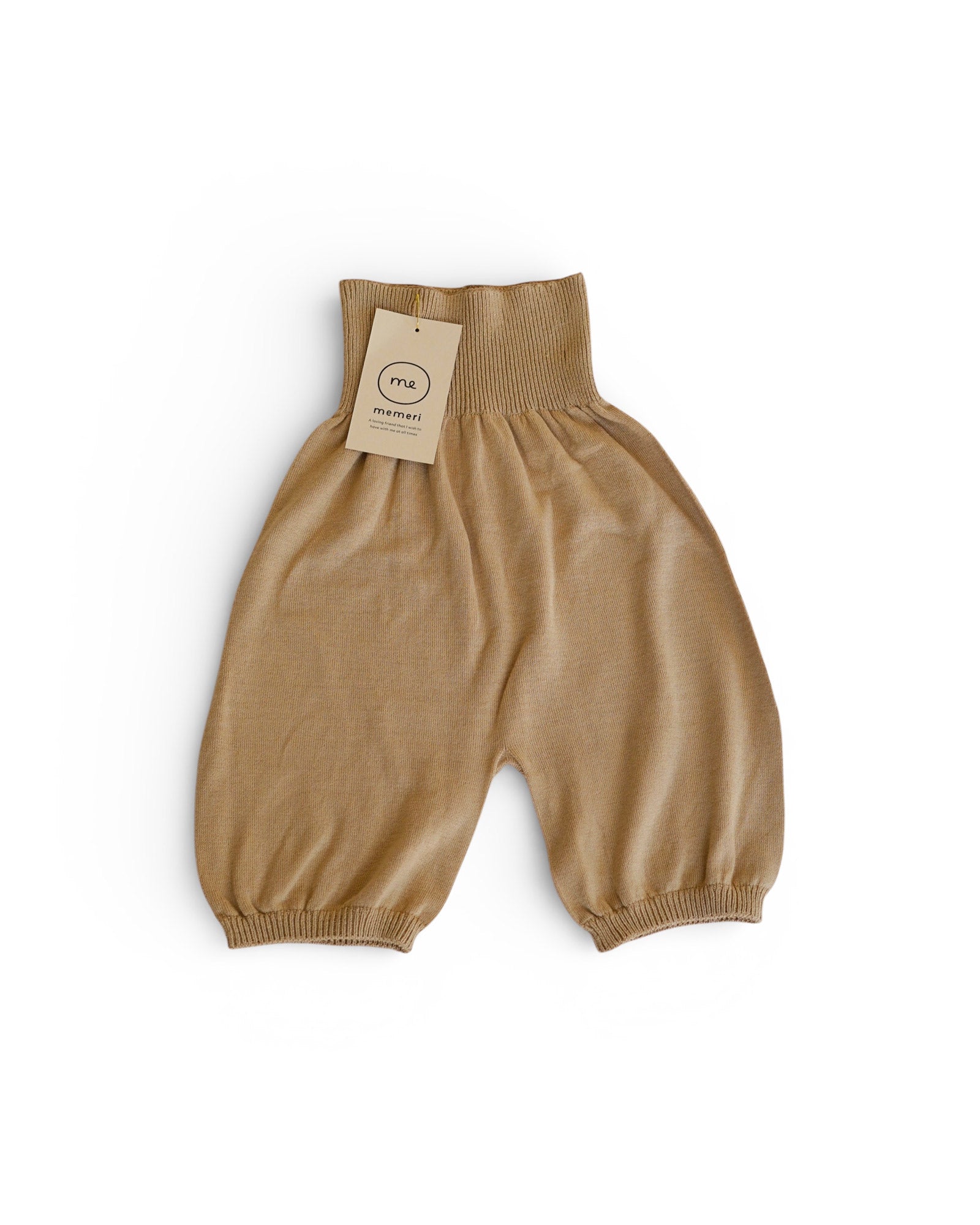 Beige, loose-fitting knit baby pants with a ribbed waistband and ankle cuffs, displayed on a white background. A beige tag reading "Pyne and Smith Clothiers" is attached. Product: Silk Cotton Seamless Pants in Beige.