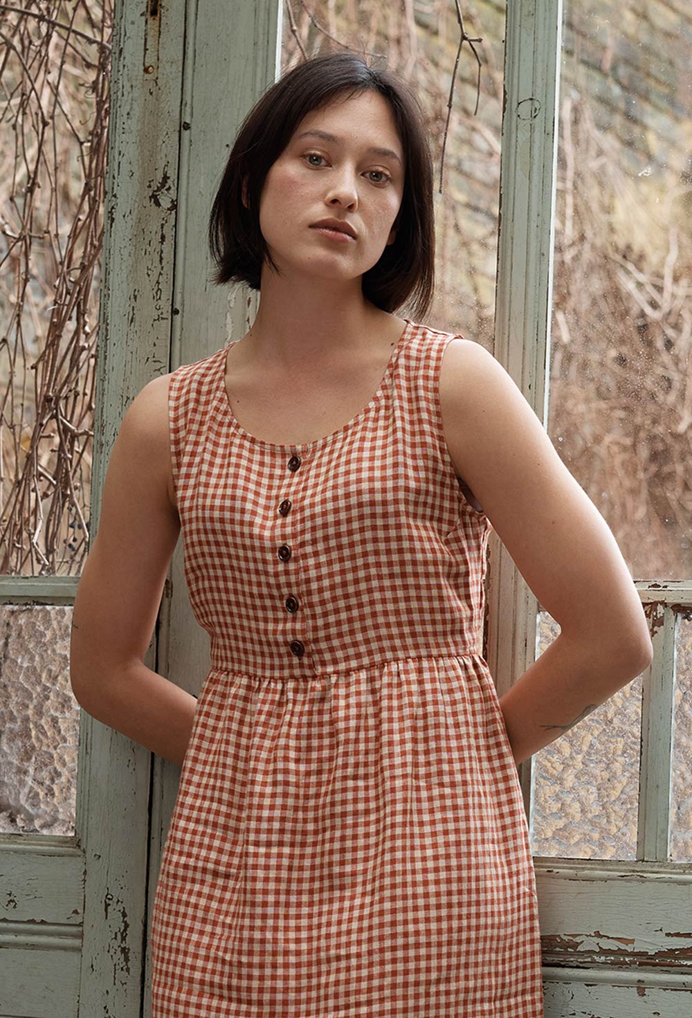 Front view of sleeveless linen dress with buttons